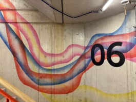 Abstrakte Wandarbeit „Sektor 6“ von Charlotte Wielage im sechsten Stock der Villa Viva, 2023; farbige Linienstrukturen auf Betonwand, 530 × 254 cm